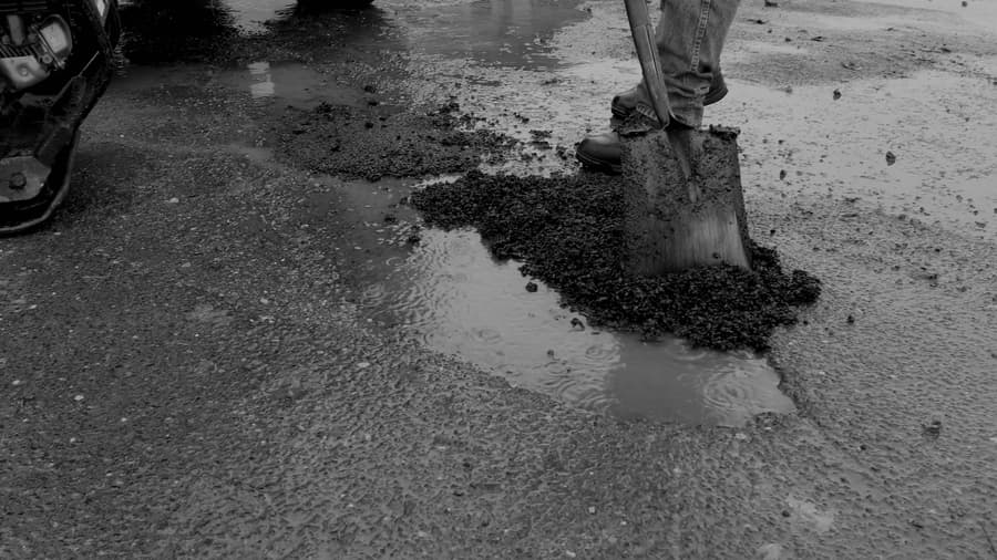 Shoveling EZ Street asphalt into a road repair